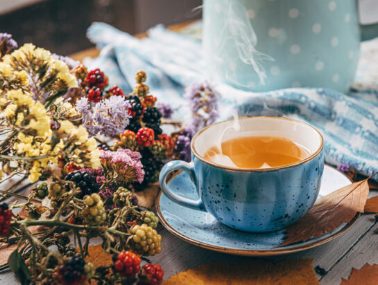 autumn warming tea on a wooden table with autumn tree leaves lyi